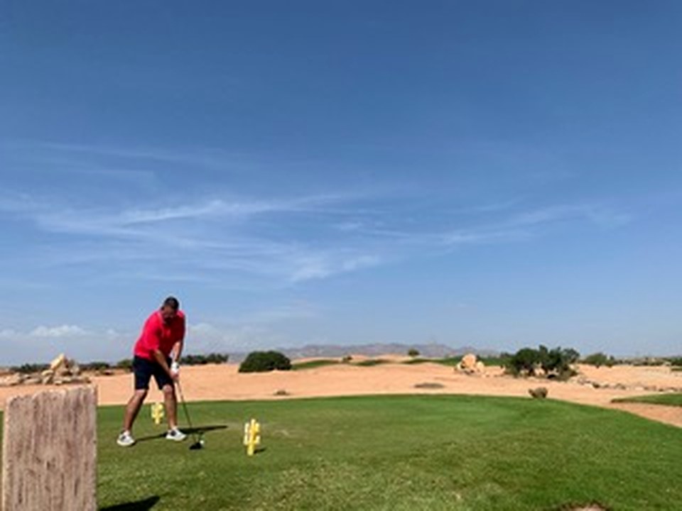 Desert tee shot under blue skies